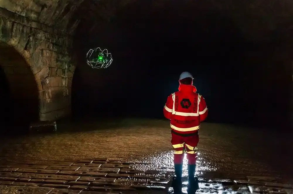 : Image of a surveyor working in a confined space or an area with difficult access within a building, illustrating site challenges