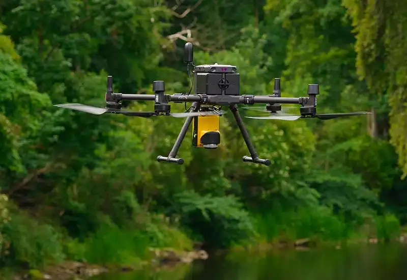Advanced LiDAR drone conducting a topographical survey over dense vegetation in the UK.